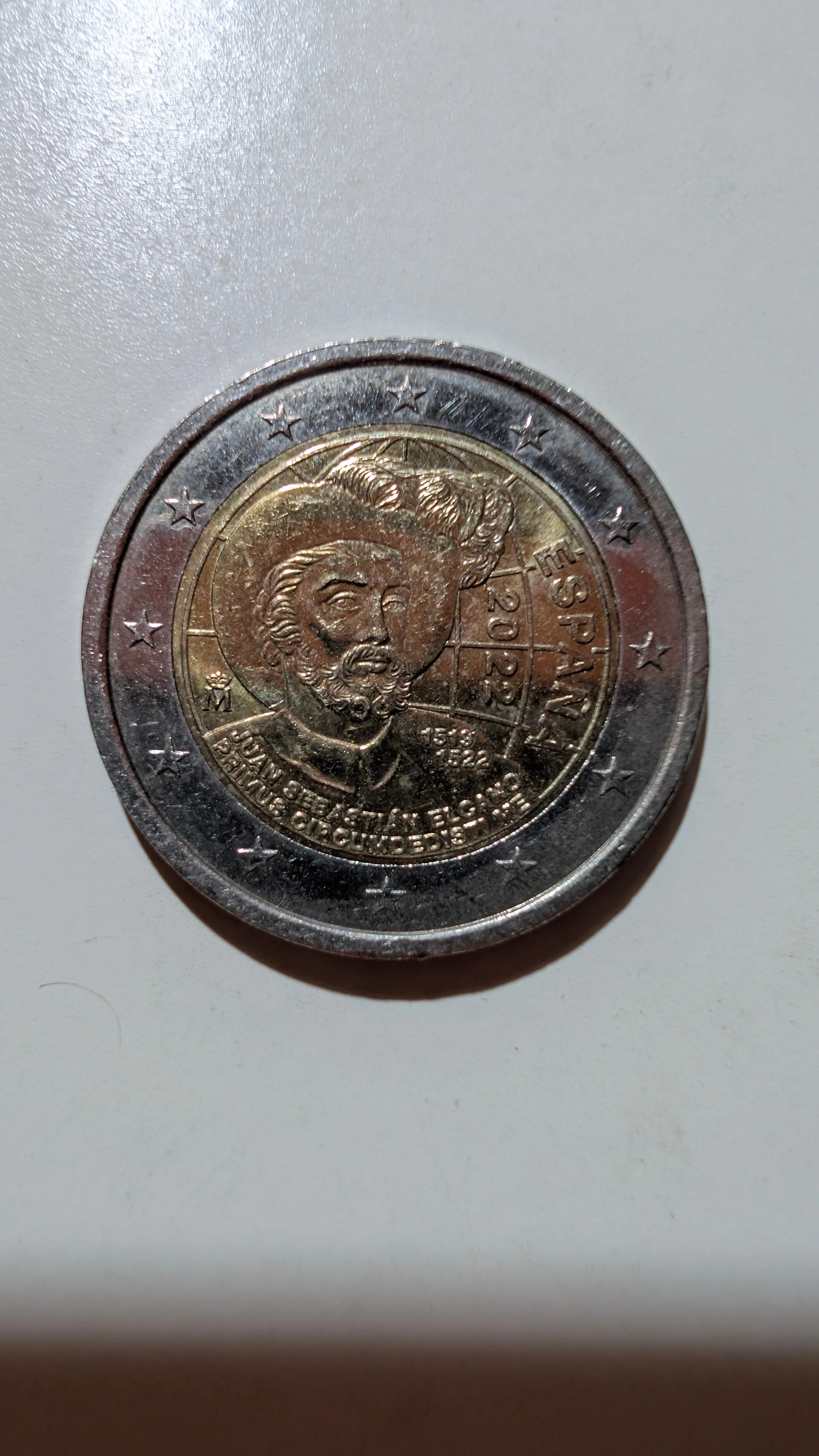 Cara nacional: 2 € de España de 2022: retrato de Juan Sebastián Elcano con el globo terráqueo y «PRIMUS CIRCUMDEDISTI ME».